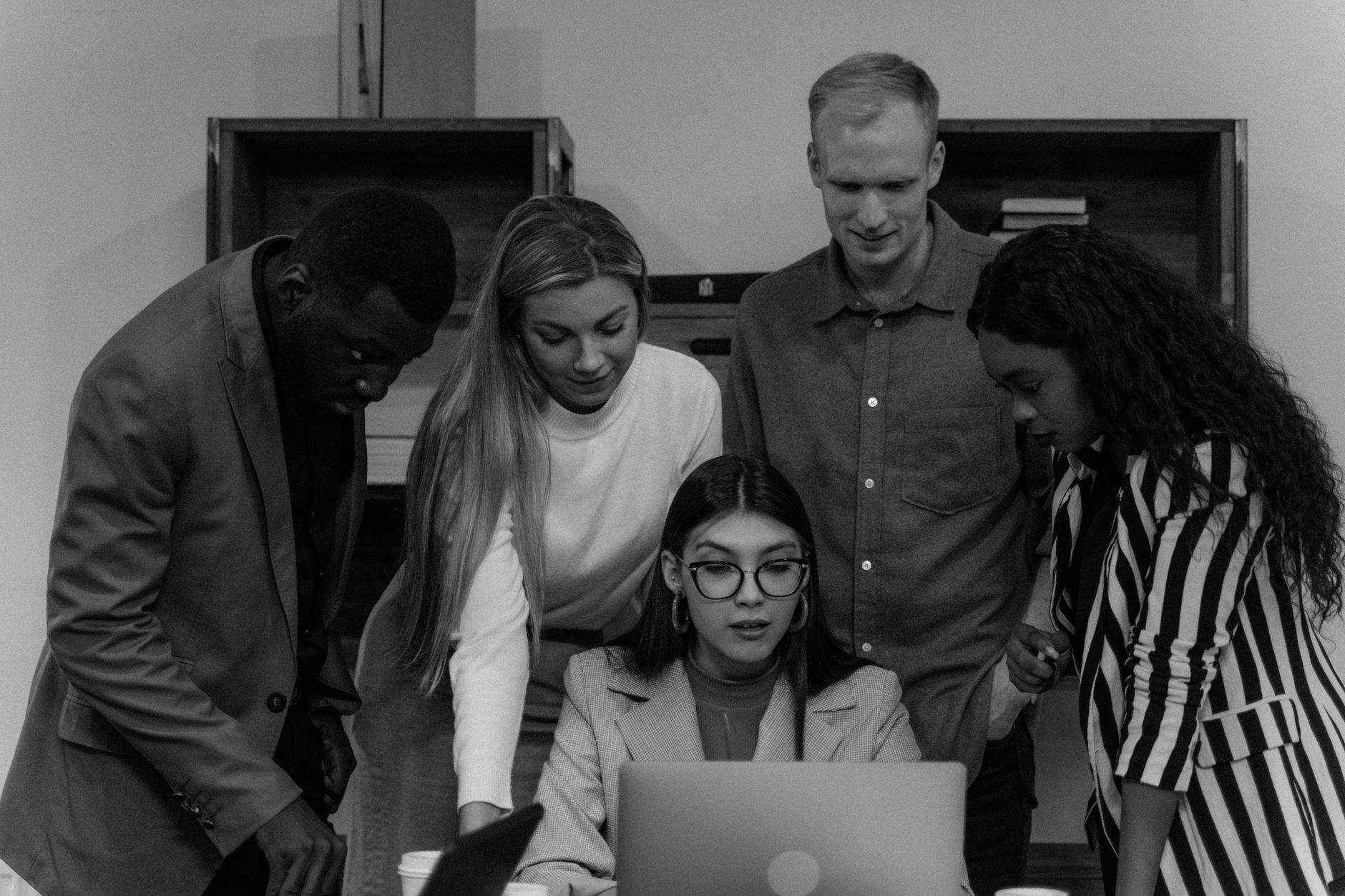 A small team gathered around a laptop