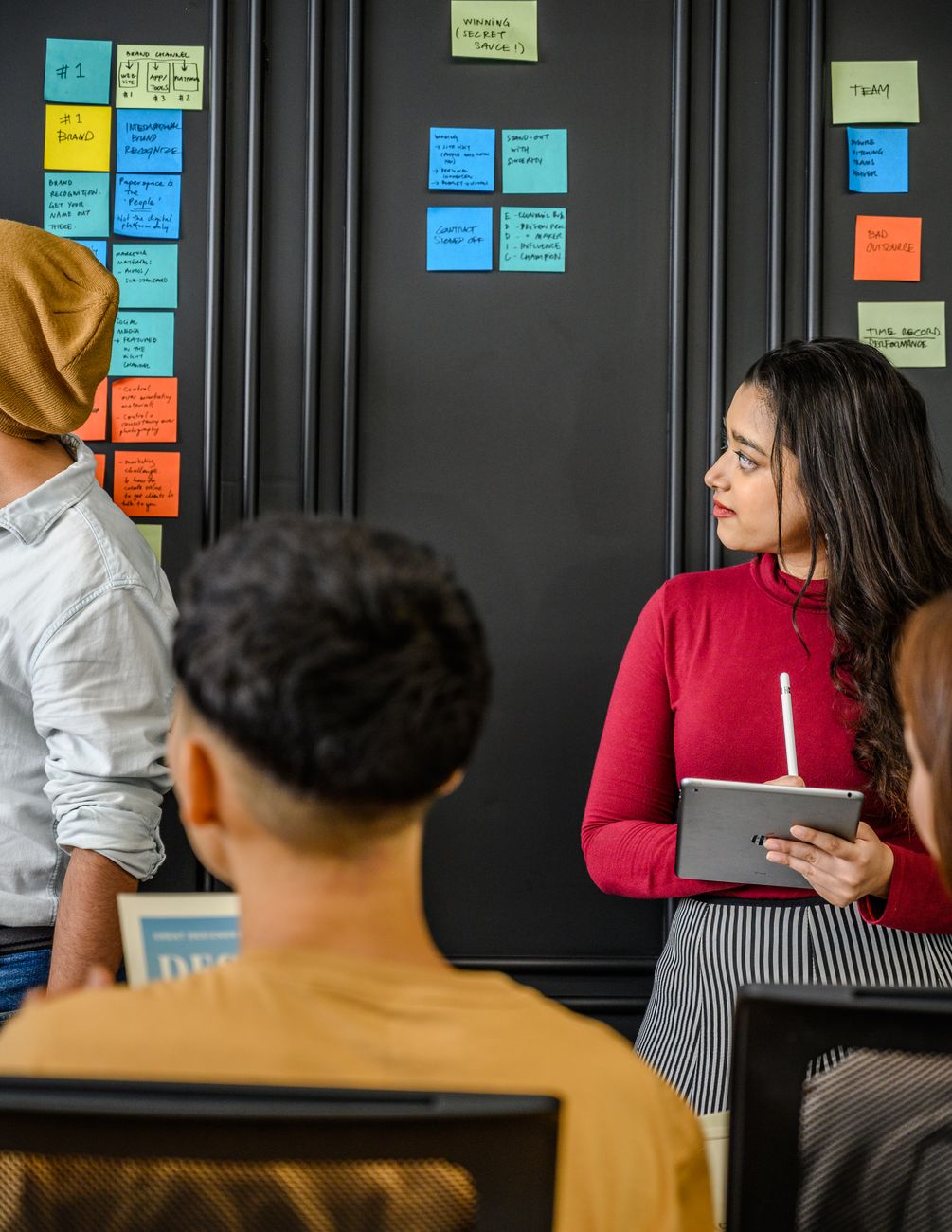Designer presenting to colleagues with a tablet