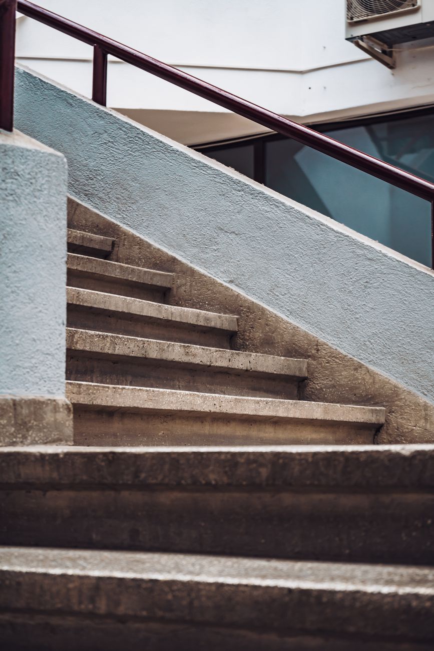 Concrete staircase with a red handrail