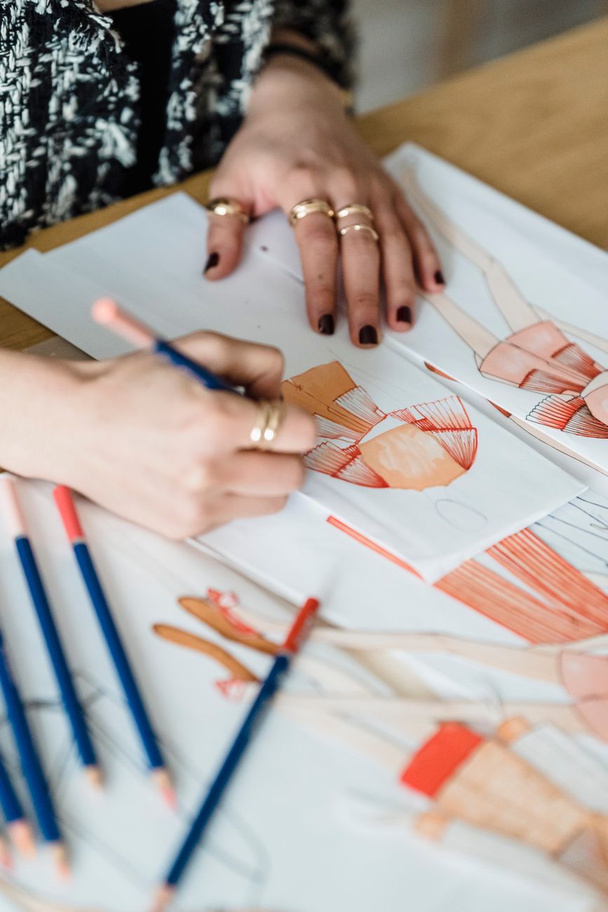 Hands sketching letterforms with coloured pencils