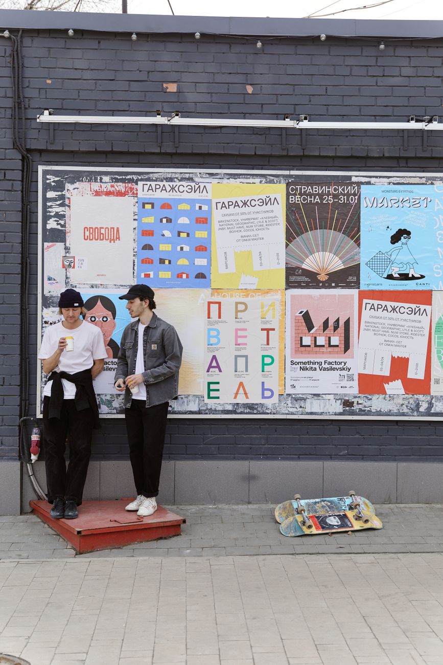 Two people standing in front of a wall of posters