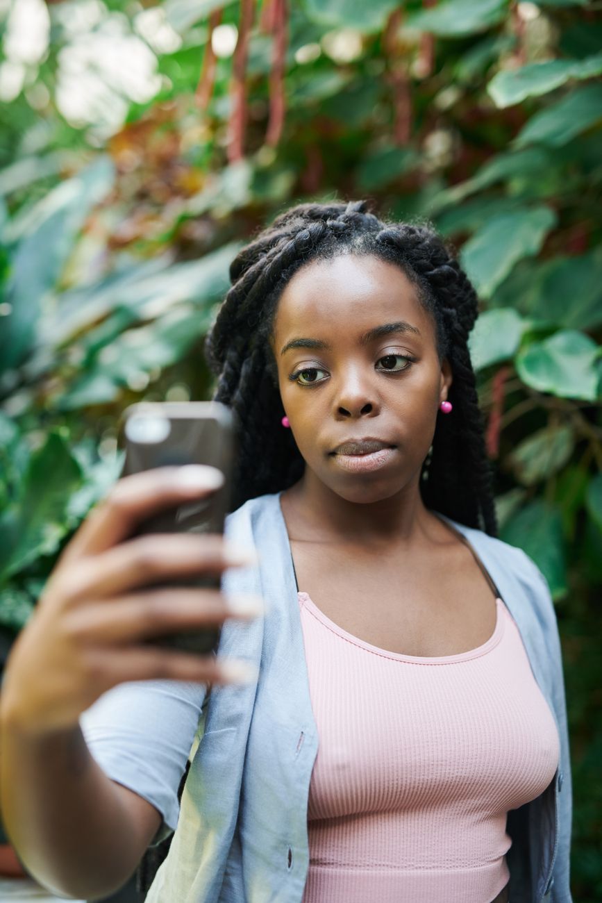 Woman taking a photo with her phone among plants