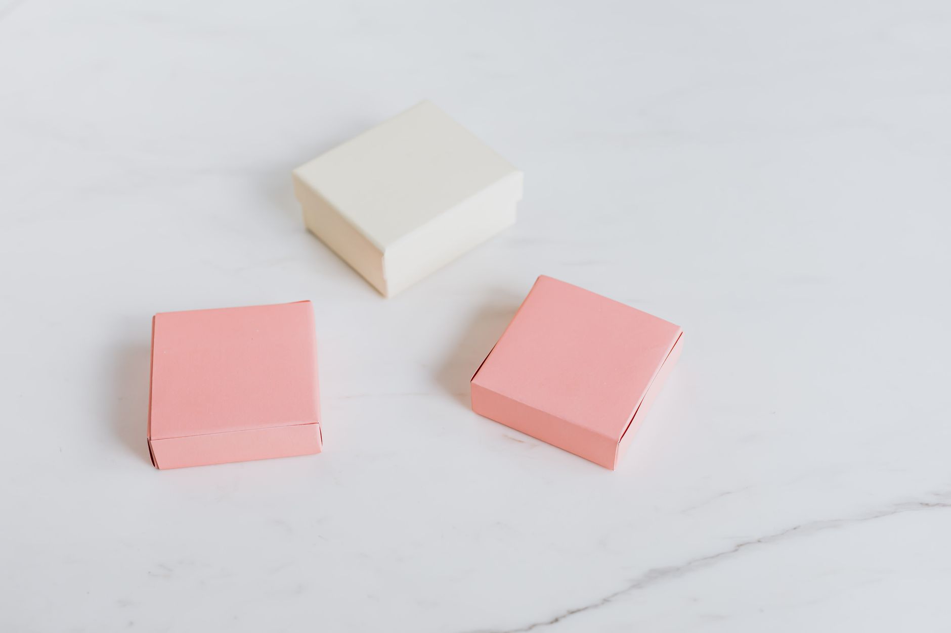 Pink and white paper boxes on a marble table