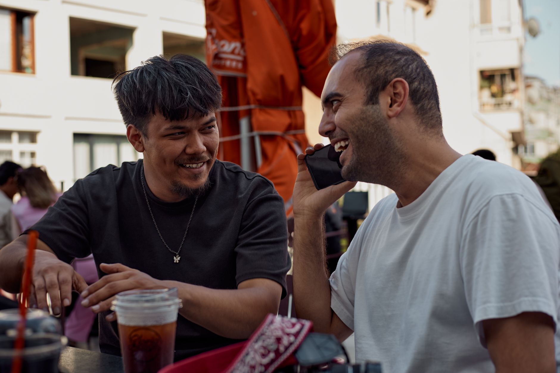 Two friends laughing at a café table