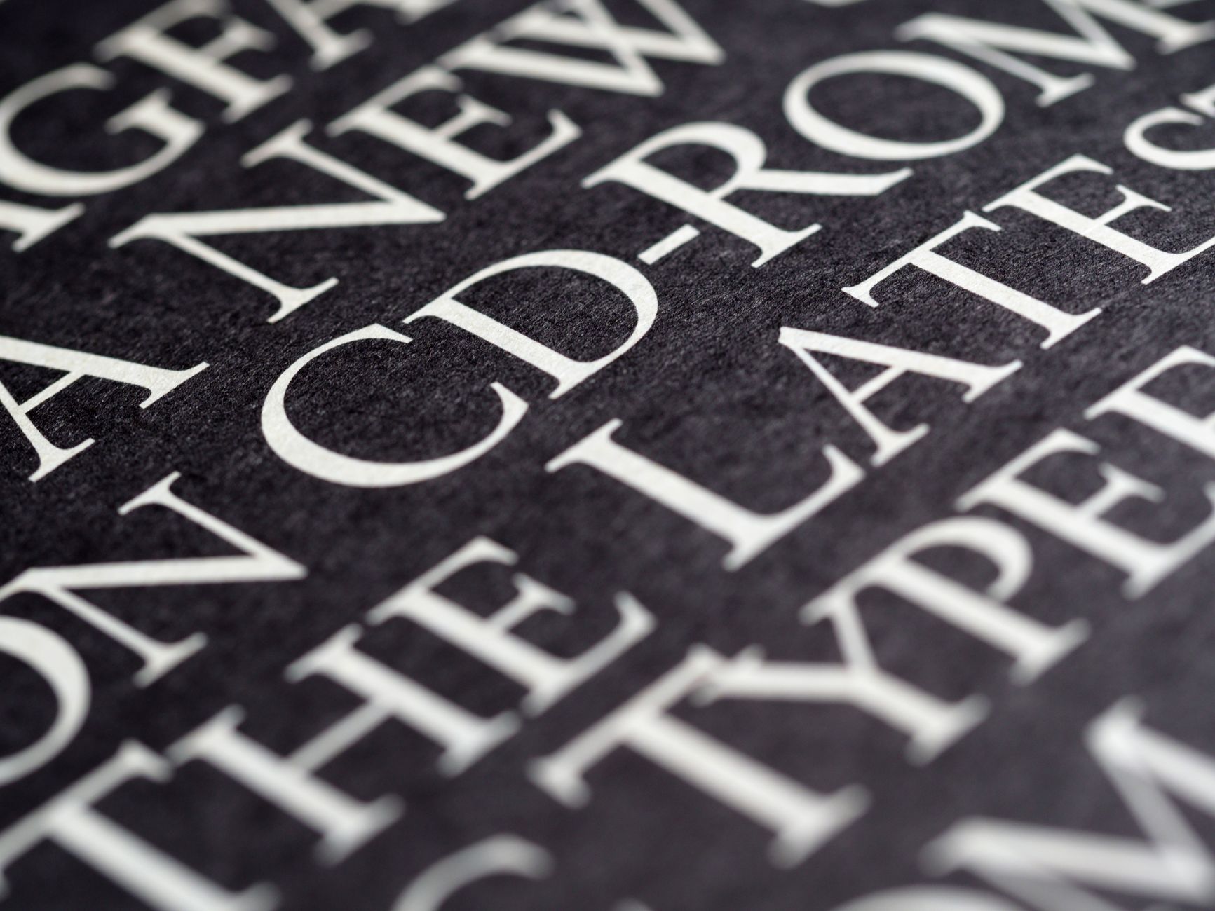 White serif letters printed on black paper